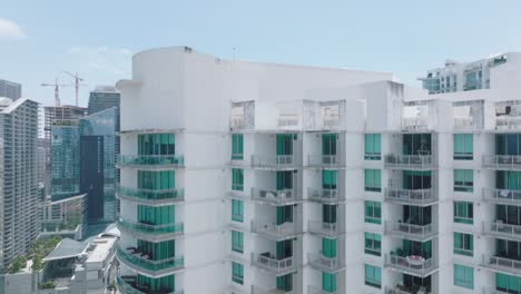 rising shot of apartment building facade with windows and balconies. revealing modern urban borough. miami, usa