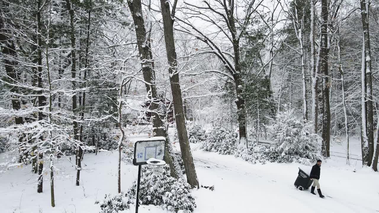 눈 오는 날 쓰레기통을 들고 다니는 청년