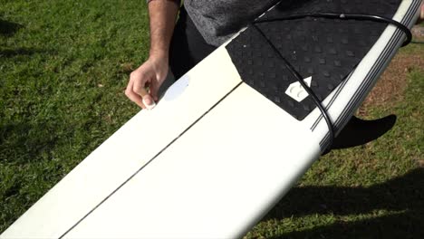 surfer puts wax, prepares the board to enter the sea