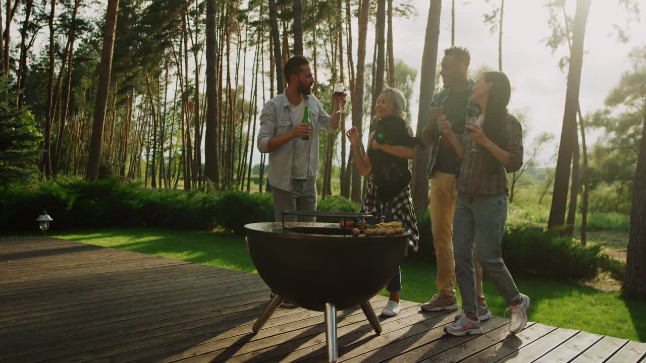 Relaxed fellows spending time on party. Happy people dancing in summer forest