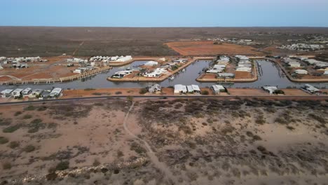 drone aérea de las casas en un puerto fluvial en exmouth rodeado por un vasto paisaje