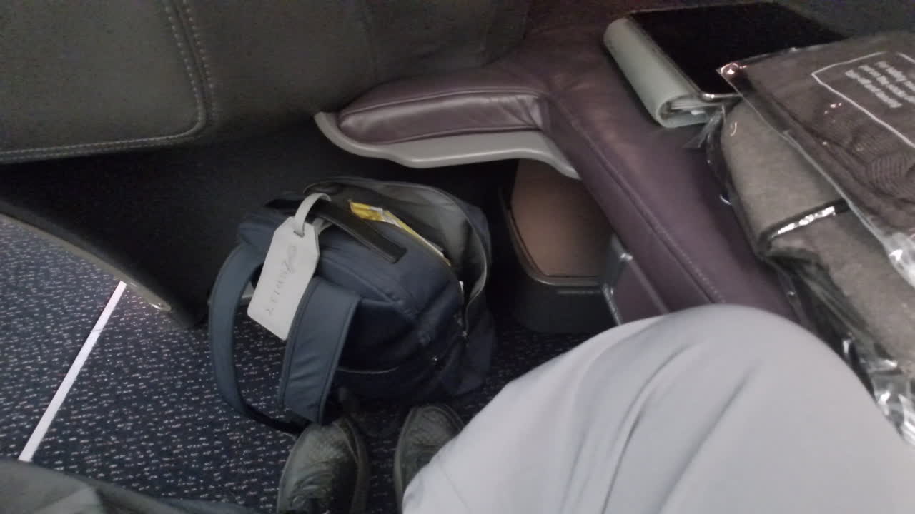Ample leg room in a business class seat on a long-haul flight.