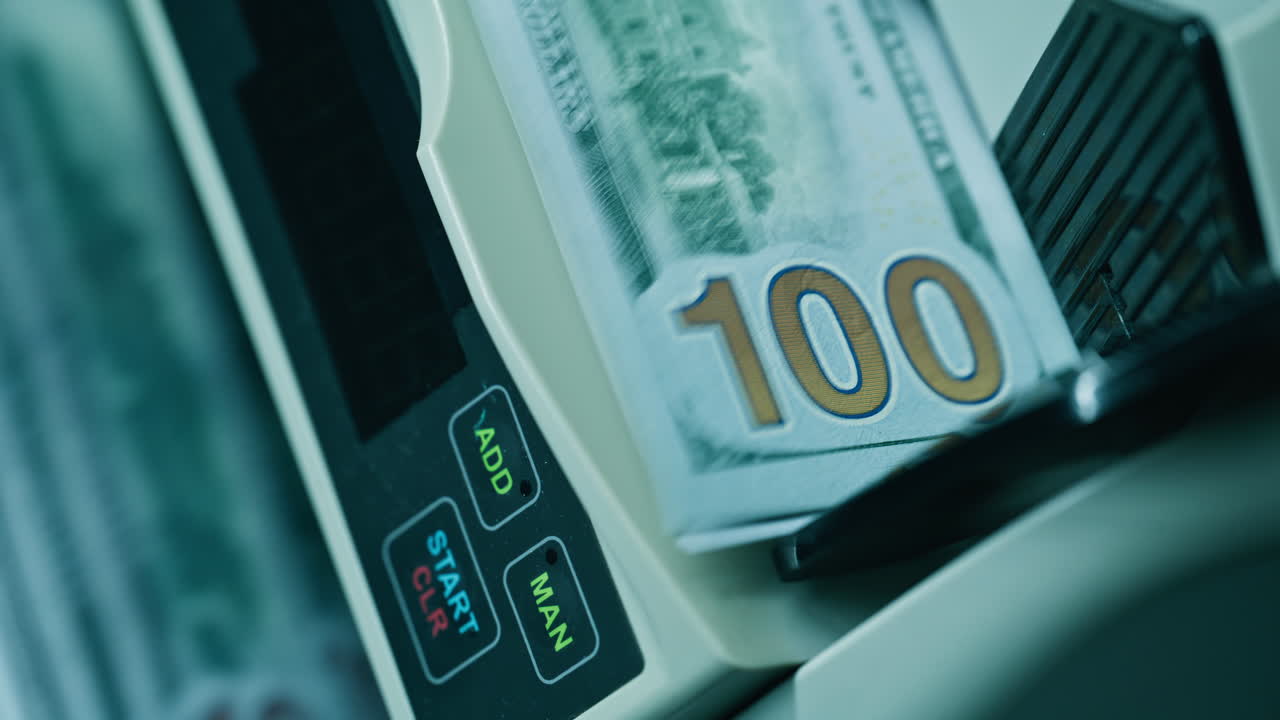 Primo piano di una mano che inserisce denaro in una conta banconote con lame rotanti. Dispositivo che sposta le banconote