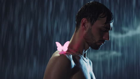 man under a waterfall with pink butterfly