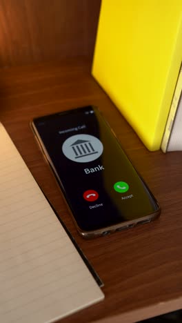 incoming call from the bank on the smartphone. vertical shot.