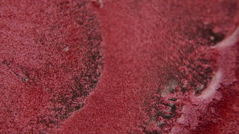 water squirting onto a red sandlike surface