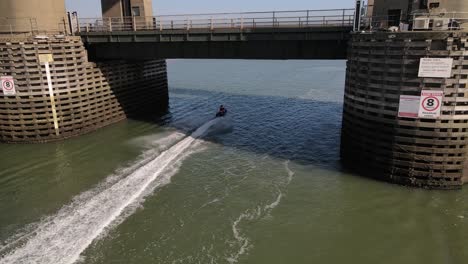 people riding jet skis under kingsferry bridge in england - aerial shot
