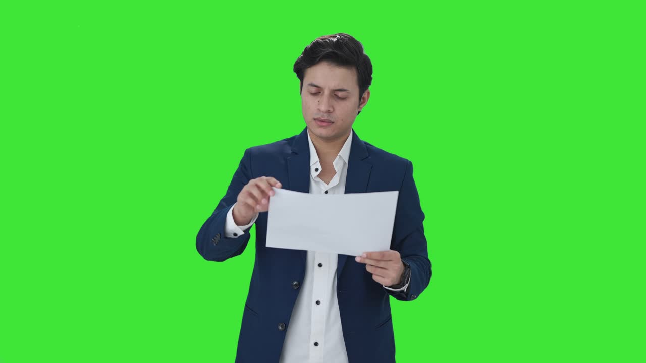Indian manager checking financial reports Green screen