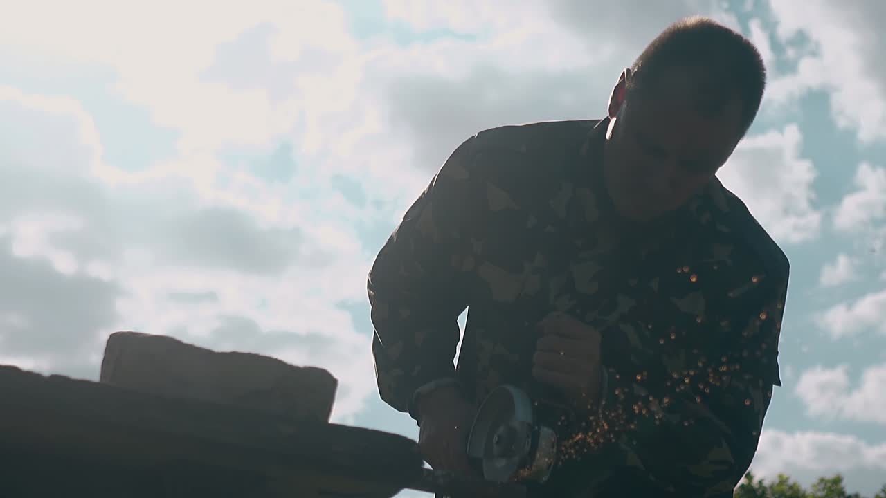 hombre de cámara lenta corta parte de metal con una sierra circular en el patio