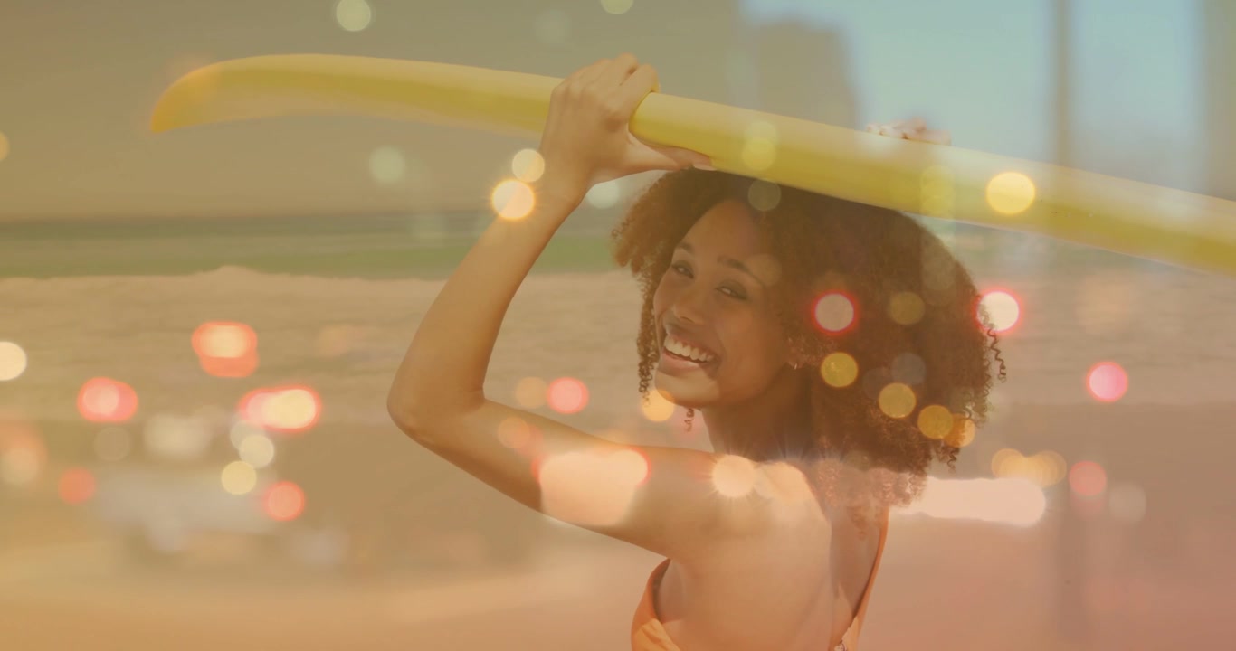 Woman holding yellow board on beach camera zooming turning meeting gaze smiling bokeh lifestyle