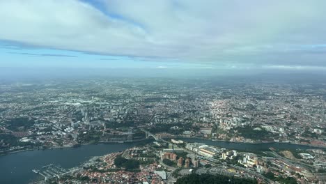 Aerial-view-of-Porto-city,-in-Portugal,-shot-from-an-airplane-cabin-during-tha-approach-to-the-airport-at-1000m-high