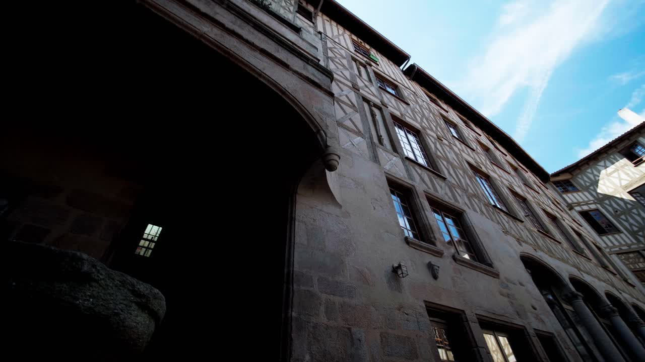 Facciate storiche in pietra e legno in un vicolo stretto nel centro di Limoges con un movimento di telecamera verso l'alto.