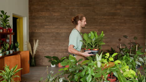 man carrying potted plants in a plant shop