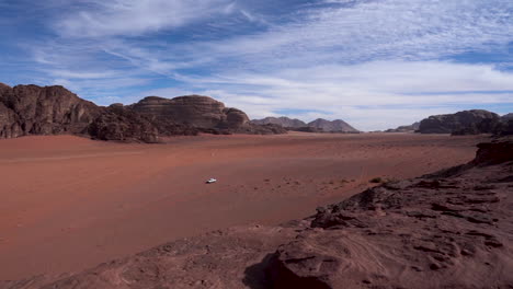 a timelapse of wadi rum desert plain with cars driving back and forth