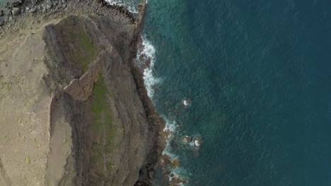 Drone-top-shot-of-waves-bounce-on-rocks-at-the-beach