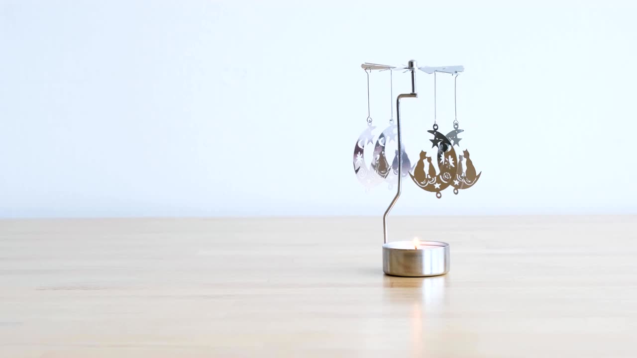 나무 테이블에 고양이와 달 모티브와 함께 금속 회전 불 카루셀