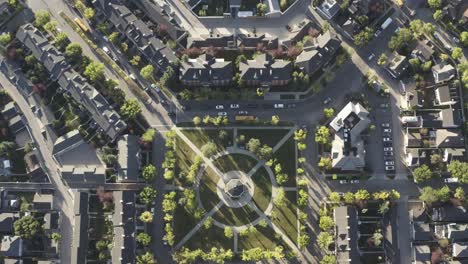 Vista-Aérea-De-Los-Pájaros-Del-Amanecer-Mirador-De-La-Plaza-De-La-Ciudad-Donde-Los-Autobuses-Escolares-Recogen-A-Los-Estudiantes-Que-Se-Dirigen-A-La-Escuela-Y-Retienen-El-Tráfico-Con-Vista-A-Una-Réplica-De-La-Plaza-Comunitaria-Hecha-Por-El-Hombre-El-Sol-Sale-Al-Estenorte-Sqr2-5