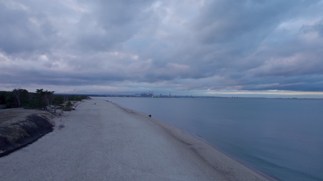 폴란드에서 흐린 날 해변을 따라 걷는 사람의 공중 전망