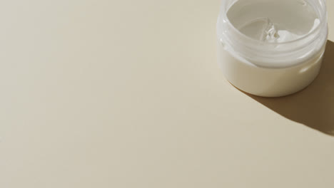 close up of cream tub with copy space on white background