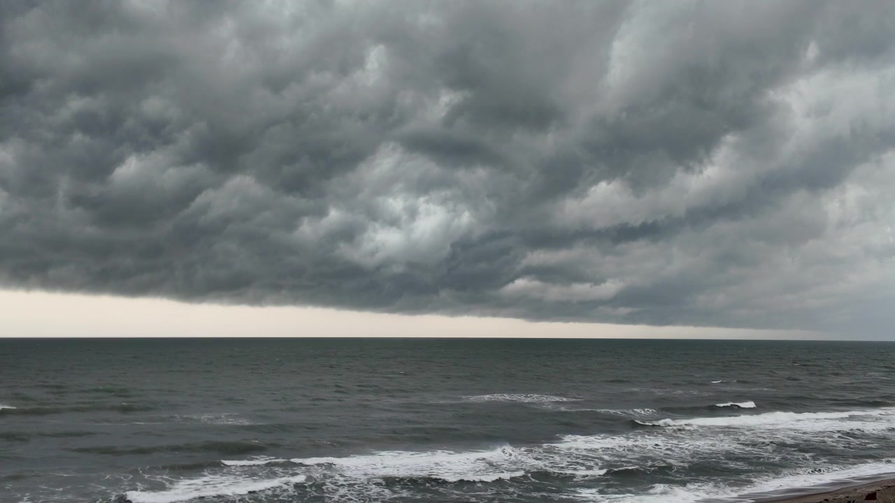 Nuvole temporalesche drammatiche si addensano sul mare in un filmato suggestivo di condizioni meteorologiche costiere avverse e la cruda potenza della natura