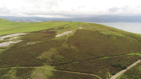 Vista-Aérea-Volando-Sobre-El-Gran-Valle-Montañoso-De-Orme-Llandudno-Ascendiendo-Al-Paisaje-Rural-Panorama