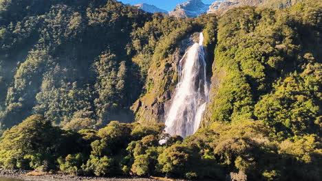 pan shot of beautiful lady bowens falls in milford sound, fiordland national park, southern alps, new zealand on a sunny day