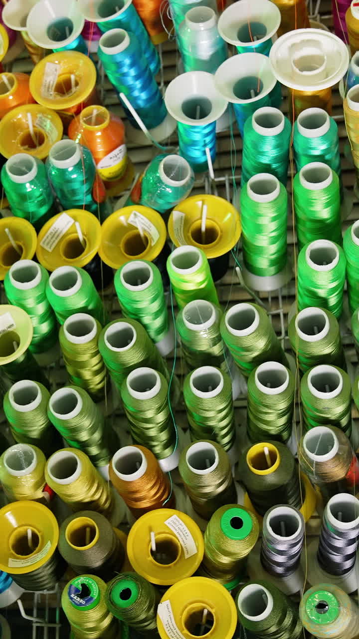 Sewing colorful threads hanging on a wall. Design cotton accessories. Vertical video