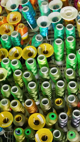 sewing colorful threads hanging on a wall. design cotton accessories. vertical video