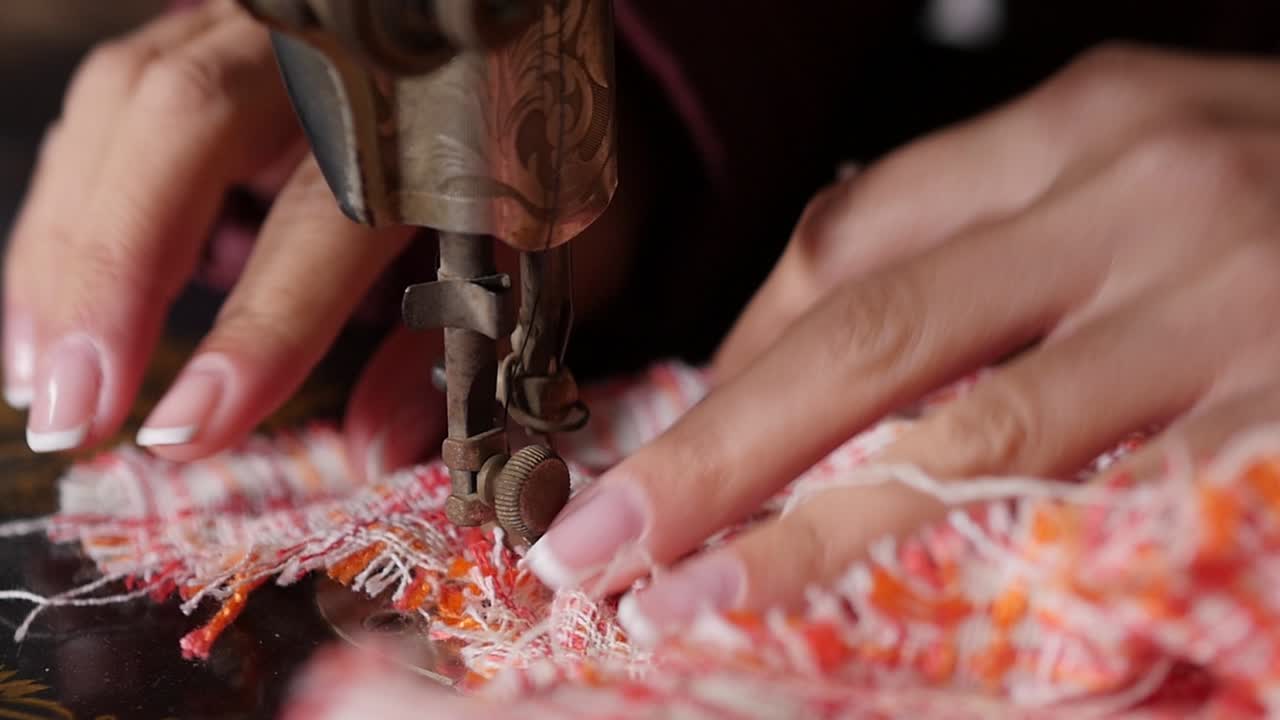 primer plano de hermosas manos mientras opera una máquina de coser