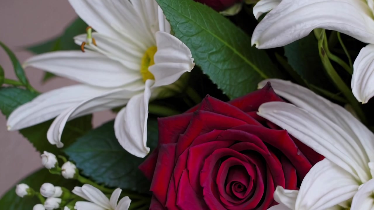 Primo piano di un vivace bouquet floreale con rose rosse e margherite bianche
