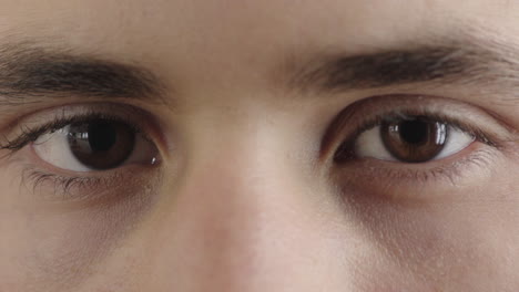 close up young man eyes looking at camera winking