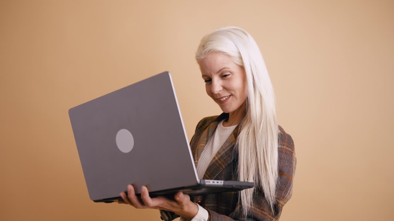 Happy Blonde Woman Using Laptop in Studio