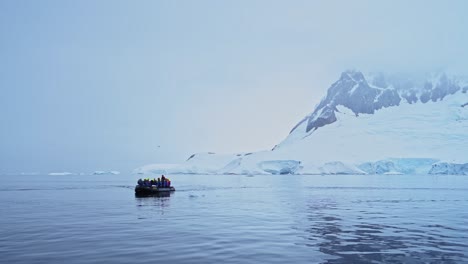 antarctica boat trip and scenery of mountains and ice on antarctic peninsula, tourists people travelling in beautiful dramatic winter scenery on zodiac boat tour, a unique adventure travel experience