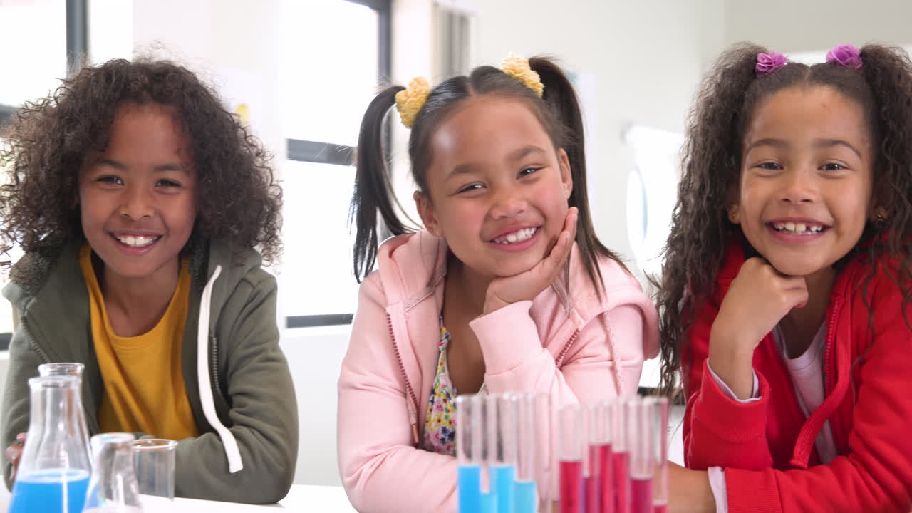Smiling schoolchildren in science class with test tubes, enjoying learning together