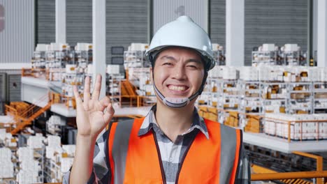 smiling warehouse worker giving ok sign