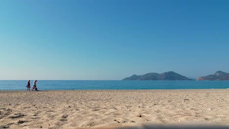 a-couple-on-vacation-walking-along-the-beach---Ölüdeniz---Turkey