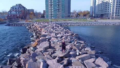 aerial young women standing on rocks near coastline