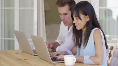 couple working on laptop computers together