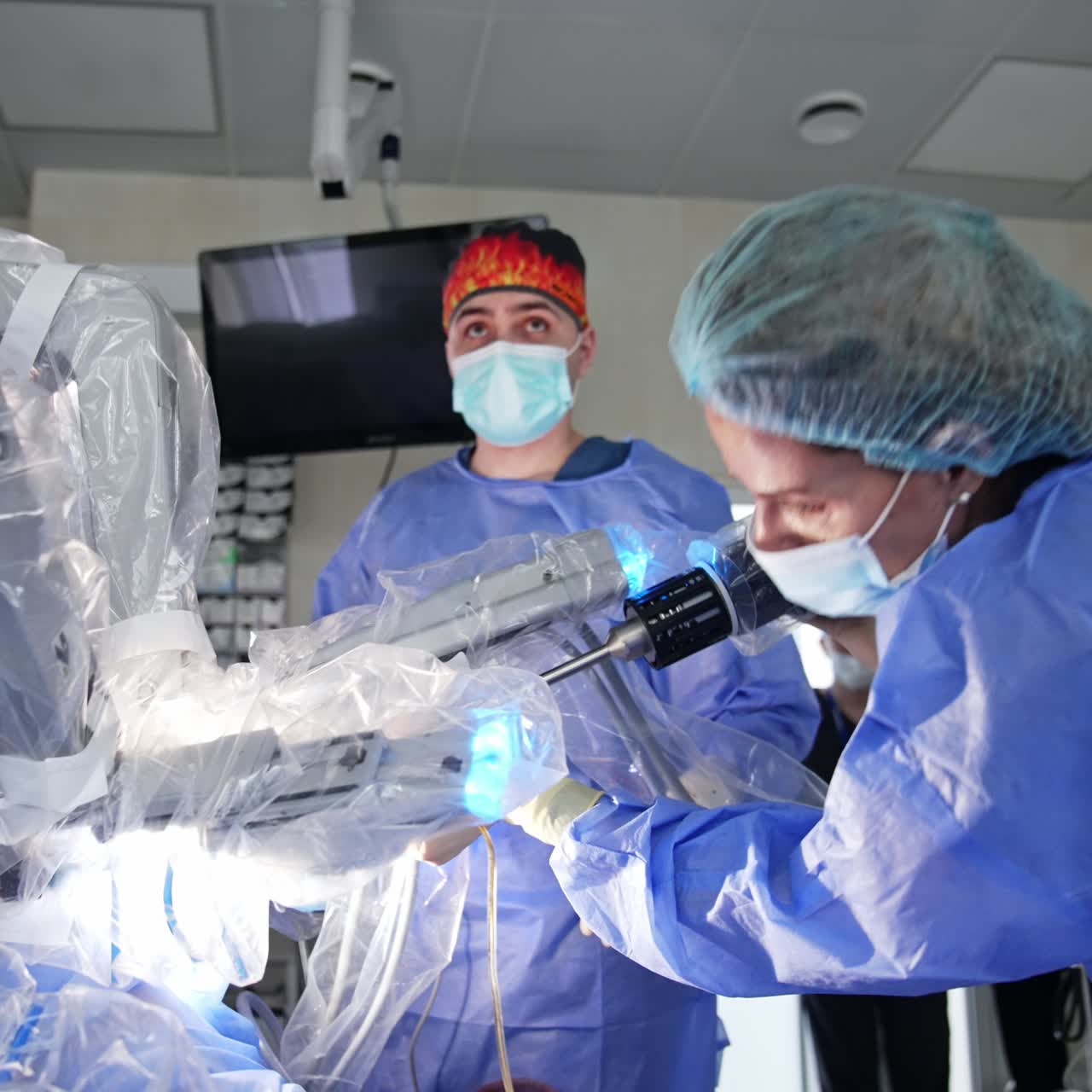 Female doctor disconnects manipulator arm from robotic surgeon. Medic puts the device into a liquid to wash