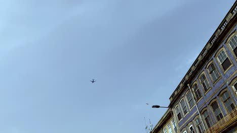 low angle view of airplane flying over skyscrapers, porto portugal