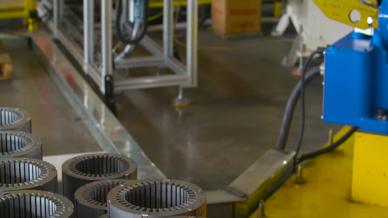 línea de ensamblaje de disparos reales dentro de una máquina de montaje robótica automatizada de bobina de motor en un proceso de producción de fábrica en una planta de fabricación de automóviles