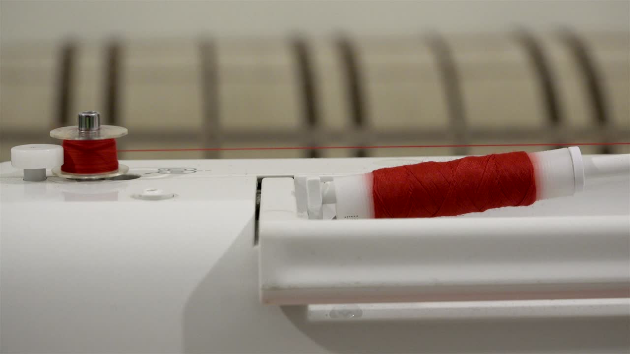 옷을 바느질 기계에 빨간 가닥 스풀의 빠른 bobbin