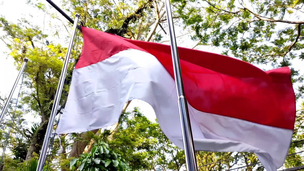 Indonesia's national flag with red and white colors fluttering in the wind during the day