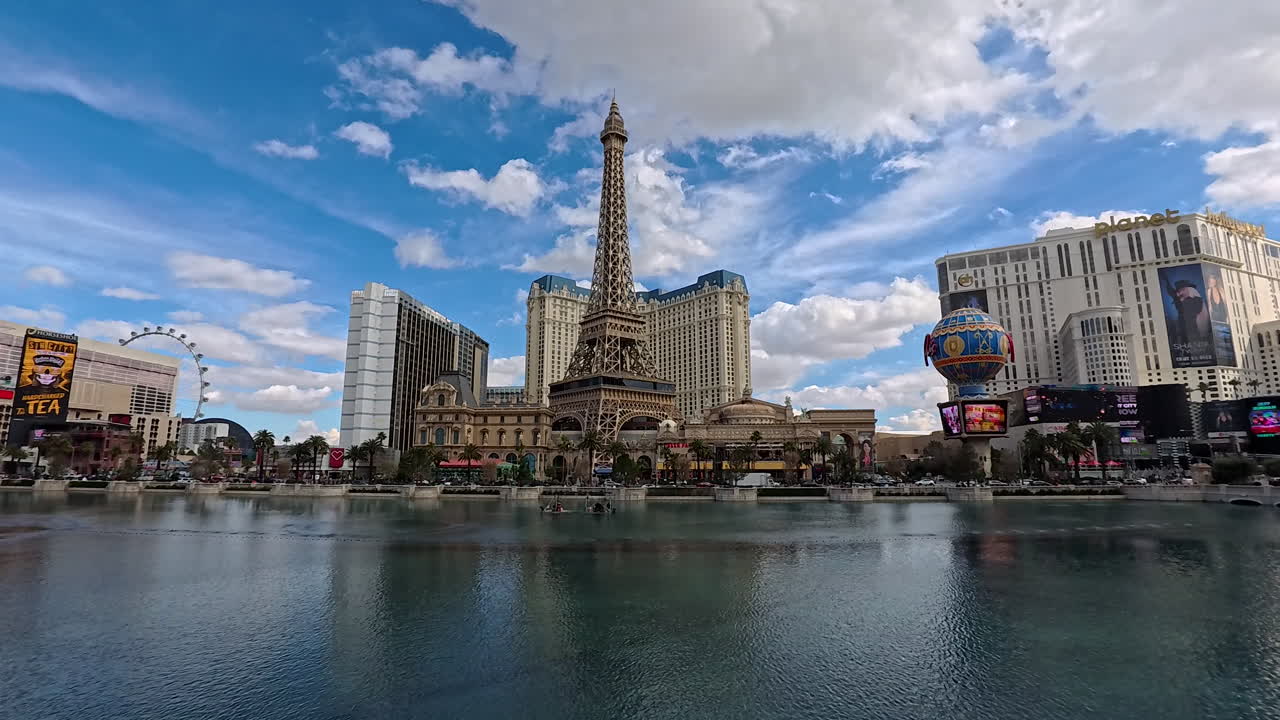 A wide view of the Las Vegas Strip showcases the iconic skyline with a large fountain in the foreground, temporarily still, highlighting the city’s vibrant atmosphere.