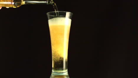 bottle filling a glass of beer