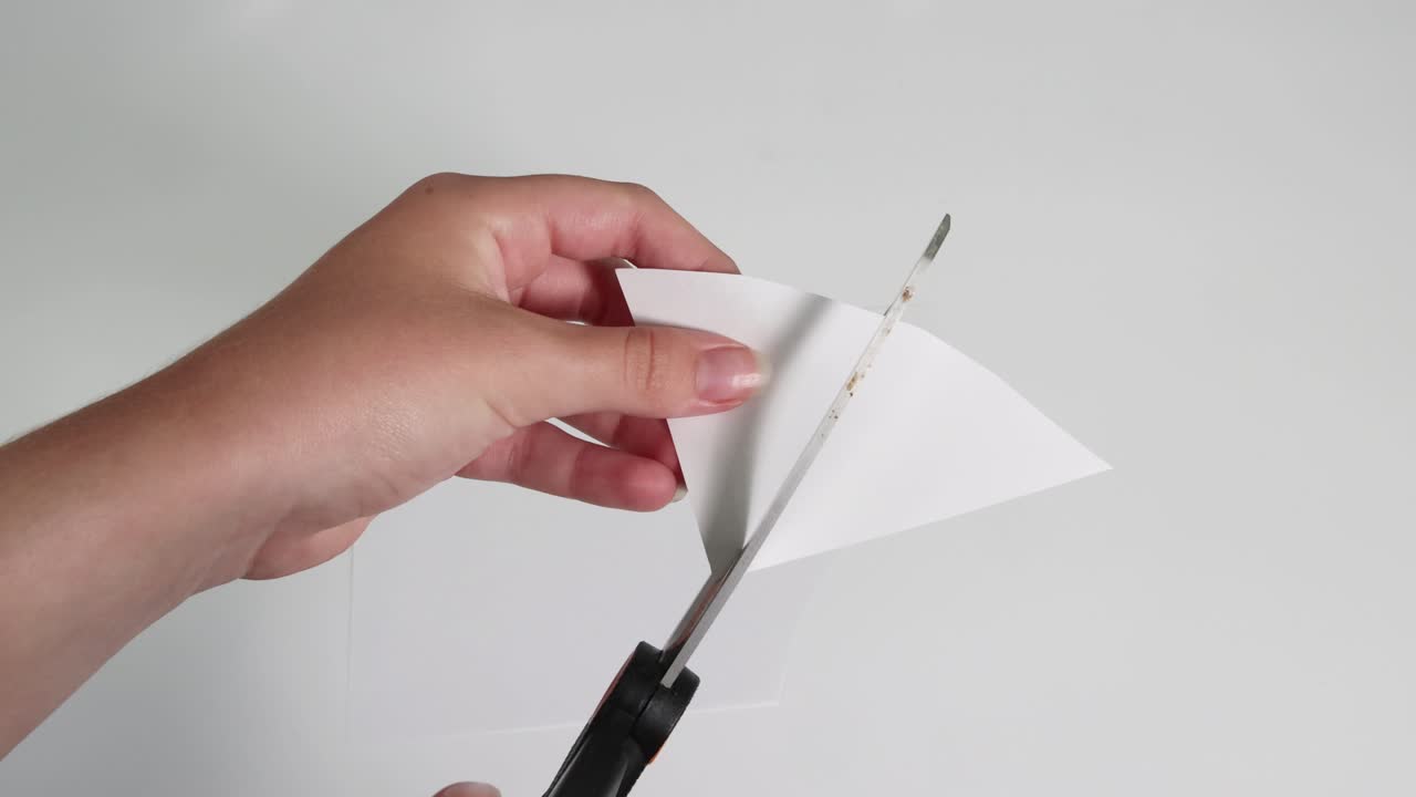 손이 가위로 종이를 순서대로 잘라내는 것