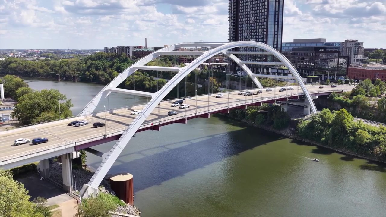 Orbita aerea lenta con drone attorno a un ponte trafficato con auto che attraversano il fiume Cumberland