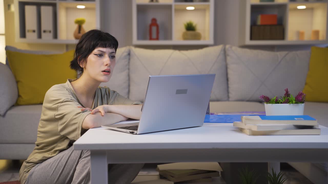 mujer joven viendo una película en el portátil por la noche en casa.