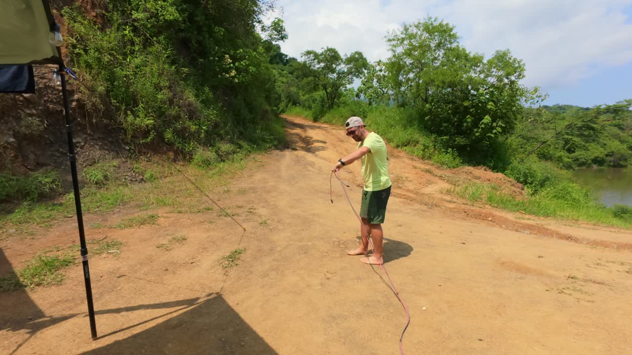 Un uomo scollega i cavi dei pannelli solari in un campeggio rustico sul lago a Jalisco, in Messico