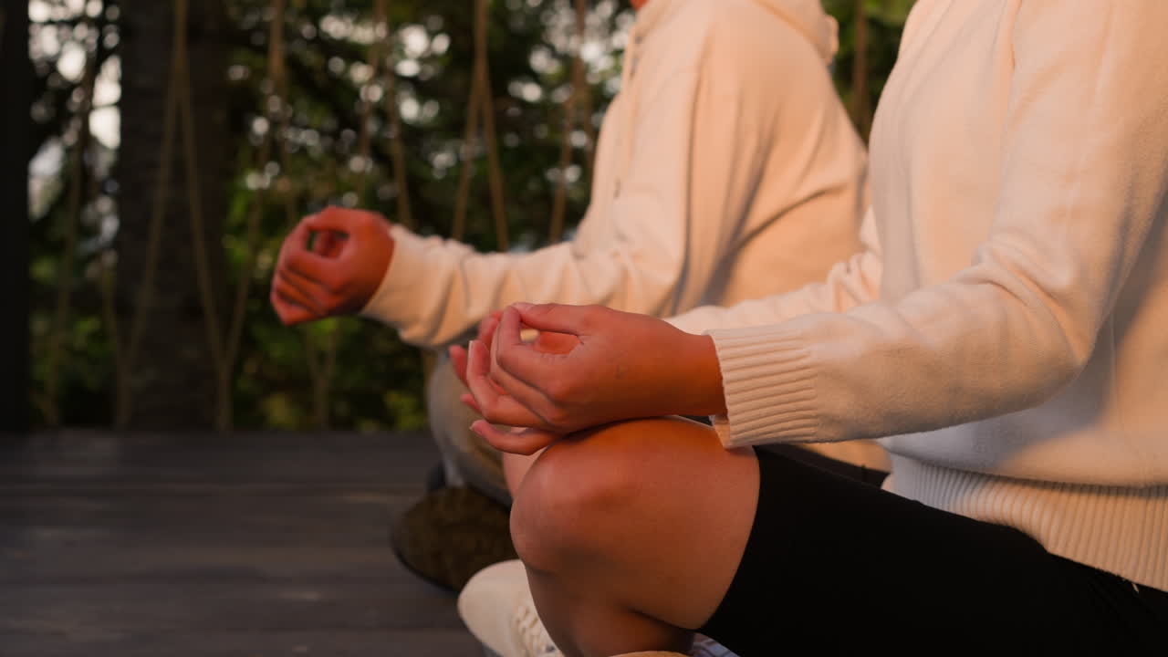 люди медитируют, сидя на деревянной земле вблизи. участники йоги размышляют о глубоких мыслях в дикой природе. терапия пары с помощью ментальных практик